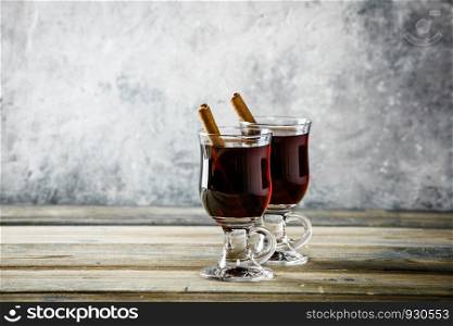 Mulled wine with spices and orange slices on wooden table. Mulled wine on rustic table