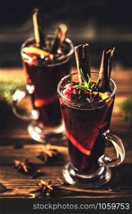 Mulled wine with spices in glasses on a rustic wooden table. Winter drink traditional for the Christmas holidays.