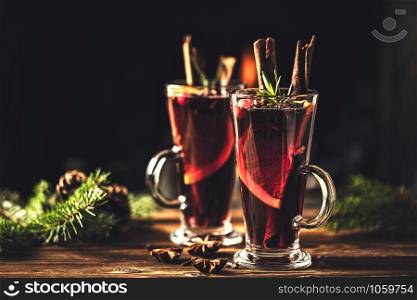 Mulled wine with spices in glasses on a rustic wooden table. Winter drink traditional for the Christmas holidays.