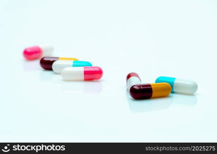 Multi-color pills on white background. Antibiotic capsule pills. Prescription drugs. Pharmaceutical industry. Polypharmacy concept. Capsule manufacturing. Healthcare and medicine. Antimicrobial drugs.