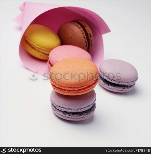 multi-colored baked macaroons from almond flour on a white background, close up