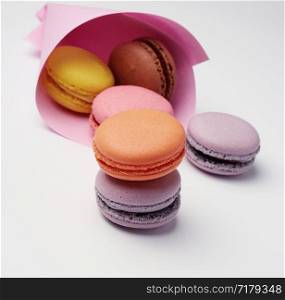 multi-colored baked macaroons from almond flour on a white background, close up