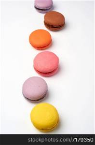 multi-colored baked macaroons from almond flour on a white background, selective focus