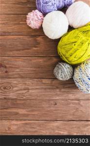 multi colored ball yarns wooden background