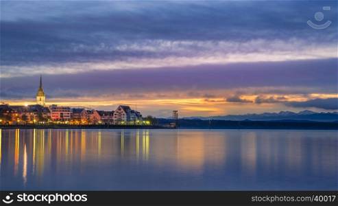 Multi-colored landscape with the Friedrichshafen town, Germany and the Bodensee lake at dawn.