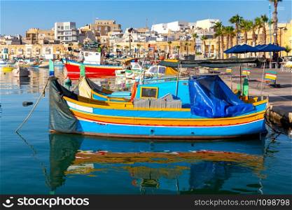 Multi-colored Luzzu fishing boats in the harbor. Marsaxlock sunny morning. Malta.. Marsaxlokk. Traditional boats Luzzu in the old harbor.
