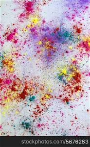 Multi-colored powder paint spread over white background