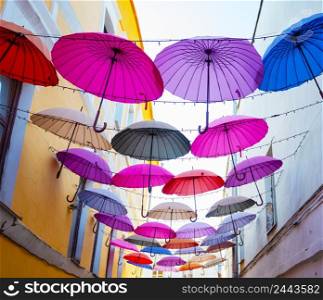 Multi-colored umbrellas in the sky above the street. Multi-colored umbrellas in sky above street