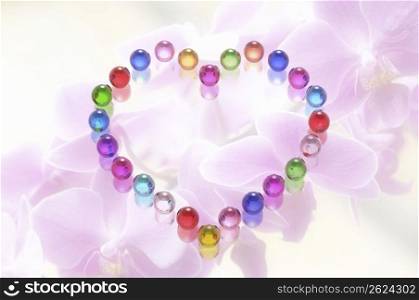 Multi coloured heart shape on a flowered background