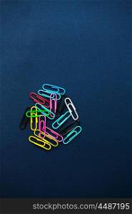 Multi coloured paper clips on plain background
