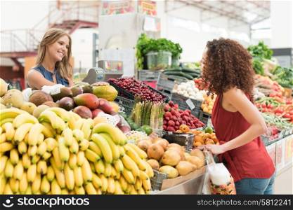 Multi-etchnic women trading organic veggies and fruits