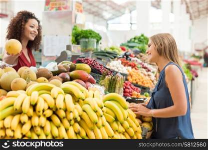 Multi-etchnic women trading organic veggies and fruits