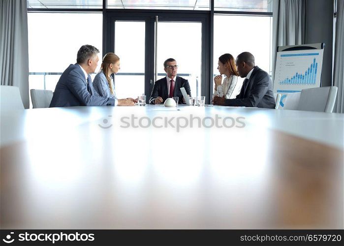 Multi-ethnic business people having discussion at conference table in office