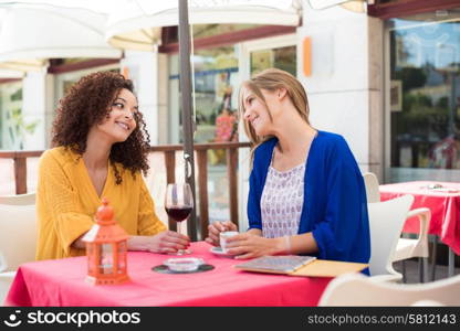 Multi ethnic friends taking and drinking in coffeeshop terrace