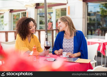 Multi ethnic friends taking and drinking in coffeeshop terrace