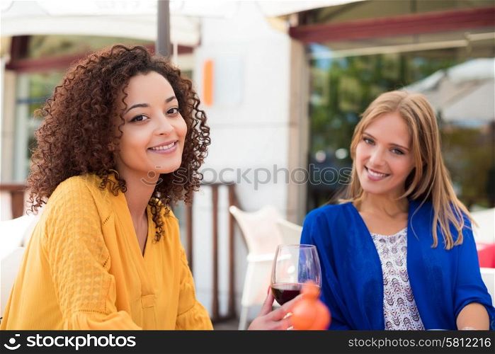 Multi ethnic friends taking and drinking in coffeeshop terrace