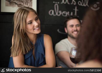 Multi ethnic friends talking and drinking in bar