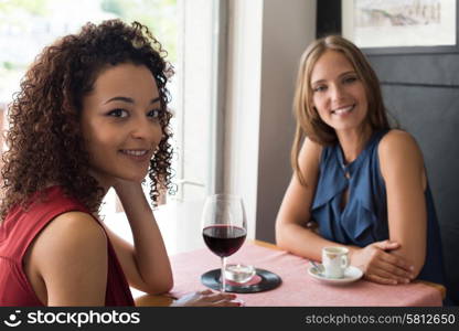 Multi ethnic friends talking and drinking in bar