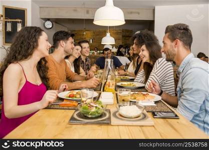 Multi-Ethnic Group of happy friends lunching and having fun at the restaurant