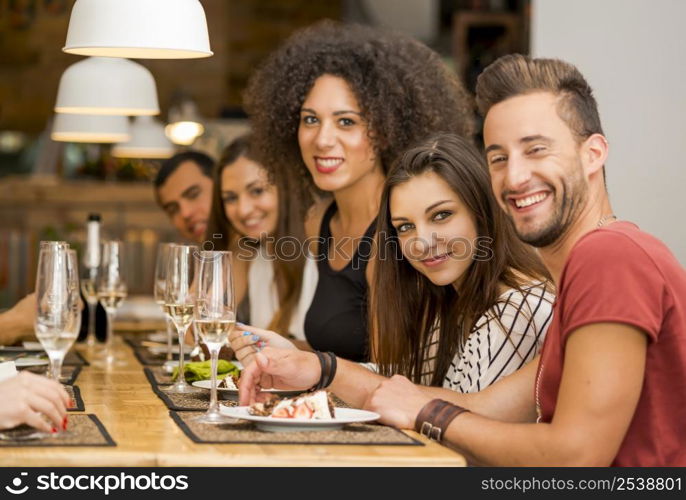 Multi-Ethnic Group of happy friends lunching and having fun at the restaurant