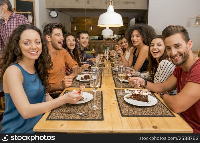Multi-Ethnic Group of happy friends lunching and tasting the dessert at the restaurant