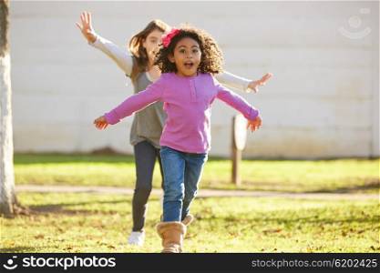 Multi ethnic kid girls playing running in park outdoor