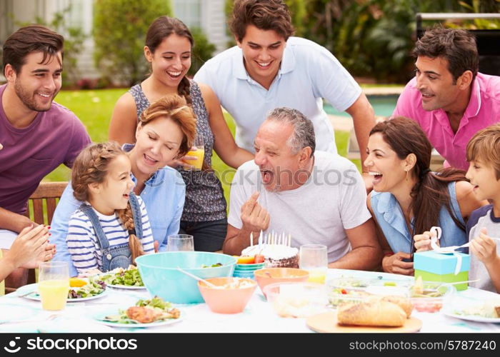 Multi Generation Family Celebrating Birthday In Garden