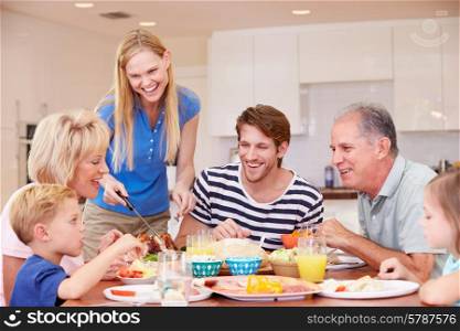 Multi Generation Family Enjoying Meal At Home Together
