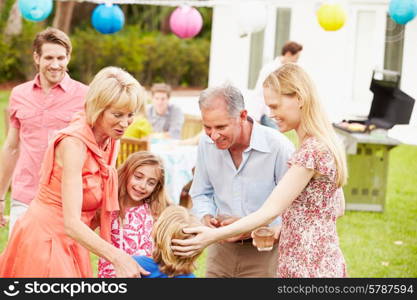 Multi Generation Family Enjoying Meal In Garden Together