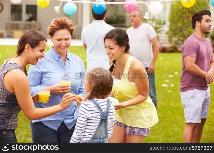 Multi Generation Family Enjoying Party In Garden Together