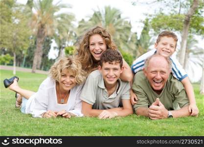 Multi-generation family enjoying sunny day in park and having fun