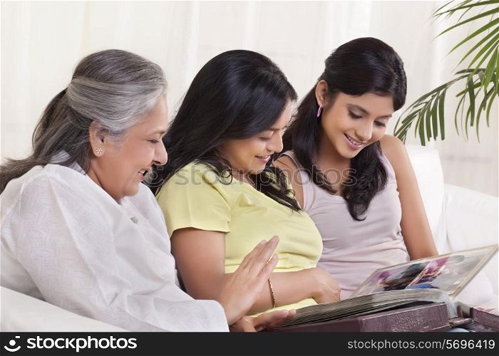 Multi-generation family looking at photo album