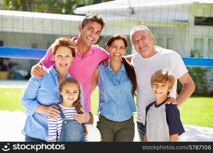 Multi Generation Family Playing Volleyball In Garden