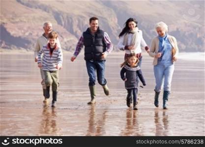 Multi Generation Family Running On Winter Beach