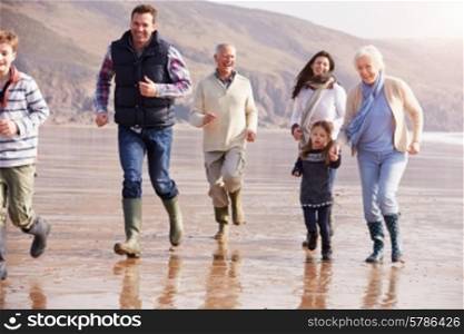 Multi Generation Family Running On Winter Beach