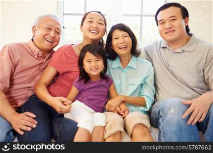 Multi Generation Family Sitting On Sofa At Home Together