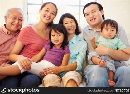 Multi Generation Family Sitting On Sofa At Home Together