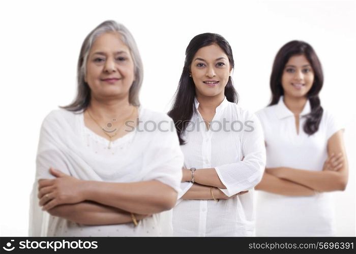 Multi generation family with arms crossed over white background