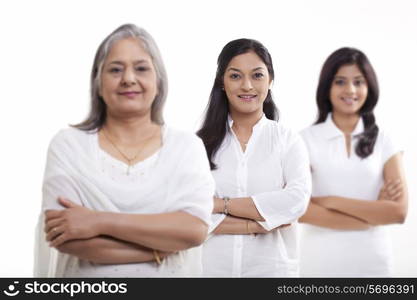 Multi generation family with arms crossed over white background