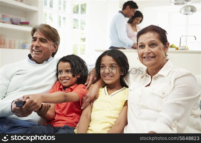 Multi-Generation Indian Family Sitting On Sofa Watching TV
