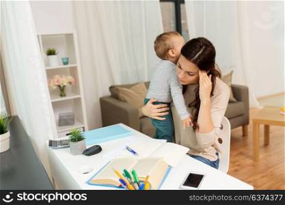 multi-tasking, education, motherhood and family concept - tired mother student with baby learning at home. mother student with baby learning at home