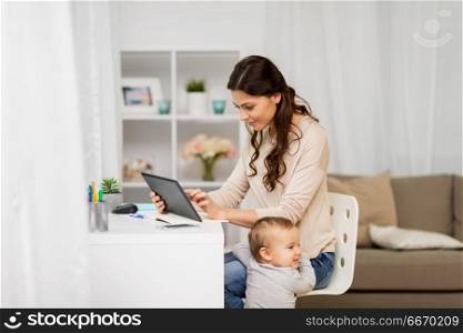 multi-tasking, education, motherhood and technology concept - happy mother student with baby and tablet pc computer learning at home. mother student with baby and tablet pc at home. mother student with baby and tablet pc at home