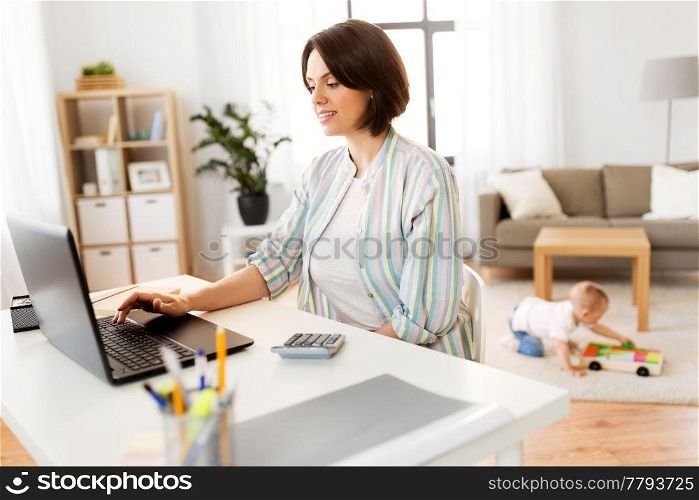 multi-tasking, freelance and motherhood concept - mother working at laptop computer and baby boy at home office. mother working at laptop and baby boy at home