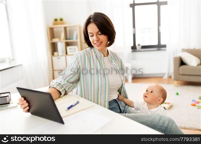 multi-tasking, freelance and motherhood concept - working mother with tablet pc computer and baby boy at home. working mother with tablet pc and baby at home