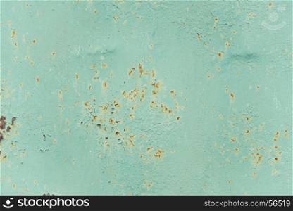 Multicolored background: old rusty metal surface with light blue paint flaking and cracking texture