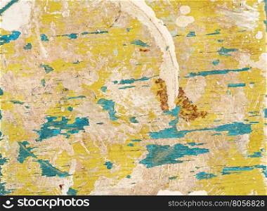 Multicolored background: old wooden multicolored surface with yellow and blue paint and cracking texture