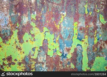 Multicolored background: rusty metal surface with blue and green paint flaking and cracking texture