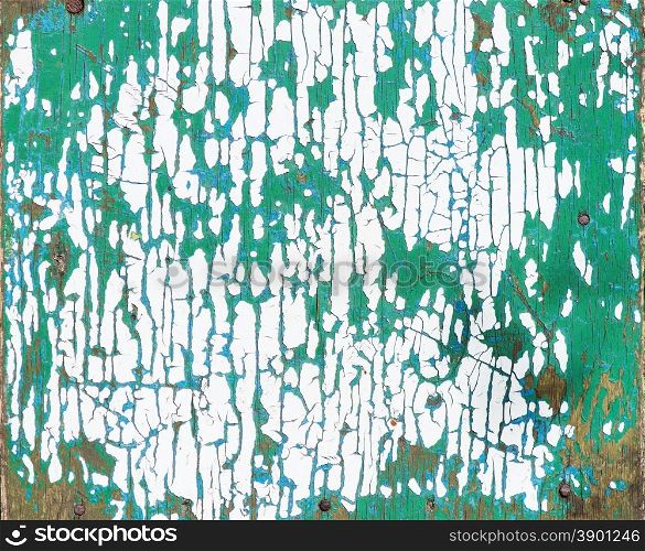 Multicolored background: wooden surface with white and green paint flaking and cracking texture