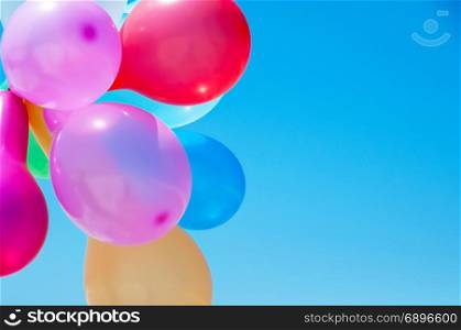 Multicolored balloons against the blue sky, close up