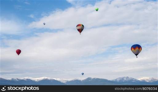 Multicolored Balloons in the blue cloudy sky